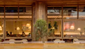 A rustic, industrial-themed restaurant interior with wooden accents and greenery.