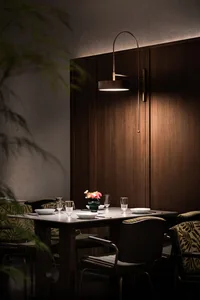 A minimalist restaurant interior made of wood with a table set for dinner.
