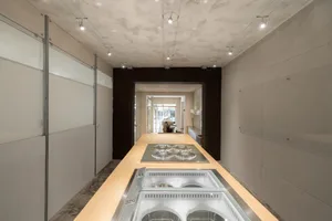 Modern retail environment with a metal countertop featuring espresso machines.