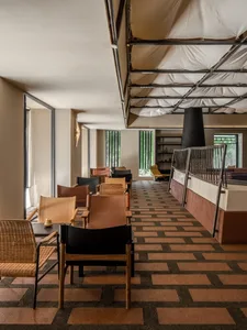Restaurant interior with wooden laminate flooring, chairs, and tables.