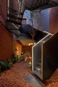 Modern interior features a metal staircase with greenery