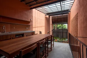 A modern kitchen with a concrete floor and wooden dining table.