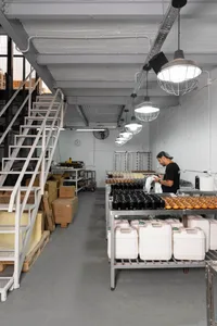 Interior of a factory with metal shelves, stairs, and lighting.