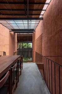 A minimalist architectural corridor featuring concrete materials in a glass-enclosed space.