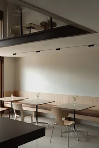 Modern cafe interior design featuring wood, concrete, and leather