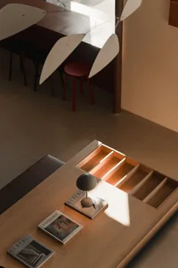 A modern home office desk with a minimalist lamp and books.