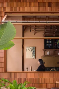 A cozy coffee shop with wooden paneling and green plants.