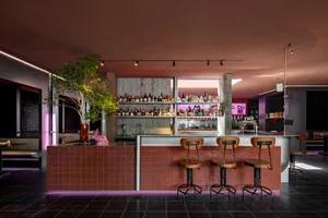 Industrial-style bar with brick counter and wooden stools.