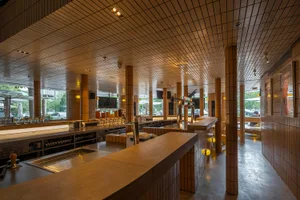 Industrial-style restaurant bar with wooden counter and metal seating