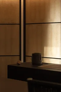 A minimalist interior with a wooden cup on a table.