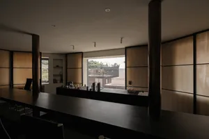 A minimalist, modern coffee shop bar counter made from wood and cloth materials.