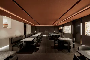 Modern restaurant interior featuring marble countertops, leather seating, and wooden furniture.