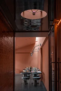 現代餐廳用餐區，牆面呈現金屬質感，搭配黑色工業風椅子。