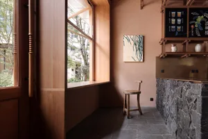 A wooden bar with stone countertops and an open-top cabinet.