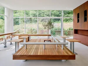 Industrial-style office space with wooden tables, steel accents, and glass walls.