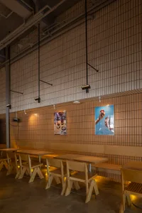 A modern restaurant interior with wooden furniture and a concrete floor.