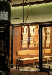 Cafe interior with wooden seating, striped curtains, and modern decor.