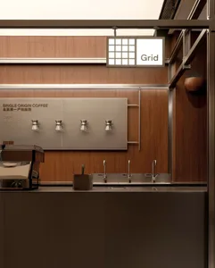A modern, industrial-style coffee shop kitchen with stainless steel fixtures and a minimalist design.