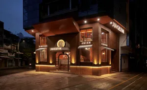 A modern storefront with a brick exterior at night with illuminated signage.