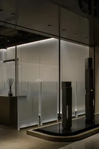 Frosted glass partitions in a modern shopping mall interior with minimalist design elements.