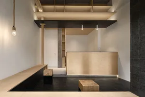 Minimalist interior design featuring laminates, wood, and concrete on black tiled floor