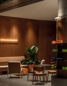 A cozy coffee shop with wooden walls and furniture, ambient lighting, and green plants