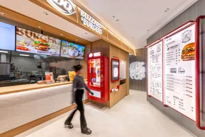 A modern interior design of a cafe featuring wooden finishes and LED lighting, with a menu board displaying burgers and sides