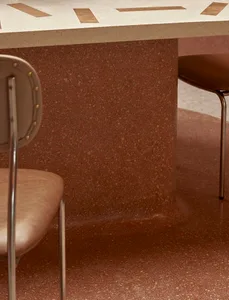 A modern dining space featuring a terrazzo floor and minimalist furniture.