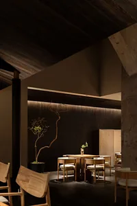 Minimalist restaurant interior with wooden furniture and dark walls