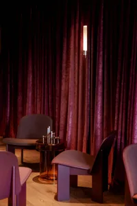 A modern restaurant interior with velvet and wooden elements.