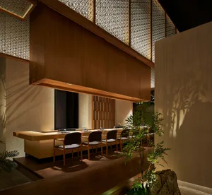 現代餐廳室內，搭配木質座椅、玻璃隔板與綠色植栽。