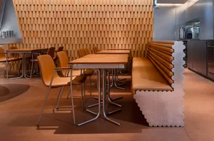 Modern restaurant seating area with chairs and tables made of wood.
