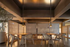 A modern restaurant interior featuring wooden furniture, with a focus on the clean lines and warm tones of the design.