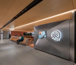A sleek, modern restaurant interior with metallic and wooden elements and a illuminated sign.