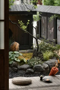 A serene minimalist Japanese teahouse featuring traditional wooden structures, stone elements, and bamboo accents.