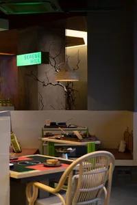 A modern restaurant interior with concrete walls, minimalist design, and industrial lighting.