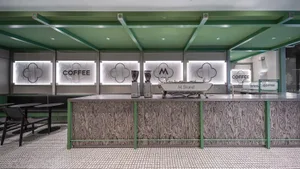 Interior view of a modern coffee shop featuring a counter made of light-colored wood.