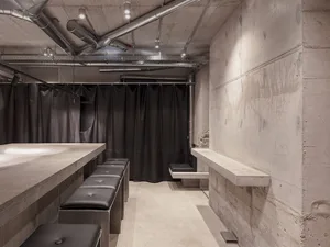 Concrete basement bar with seating and industrial design elements.