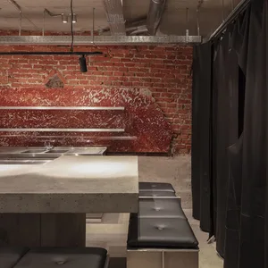 Industrial-style bar featuring a concrete countertop and red brick wall.