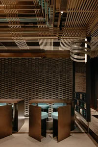 A minimalist restaurant interior featuring concrete walls and wooden furniture.