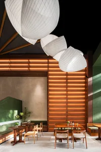 Modern cafe interior with wooden tables, chairs, and hanging lights