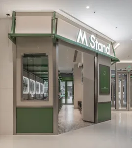 A modern coffee shop interior with a minimalist design and green accents.