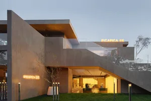 Modern building with a concrete exterior and illuminated signage.