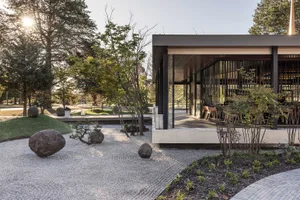 An image featuring a modern Japanese garden with concrete and glass elements.