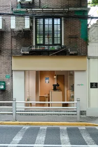 A photograph of a storefront with a concrete facade viewed from the street.