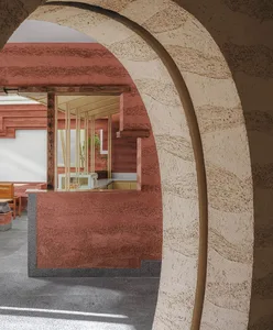 Industrial-style cafe with concrete walls and arched doorways.
