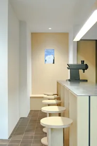 A modern coffee shop with industrial design elements and wooden stools.