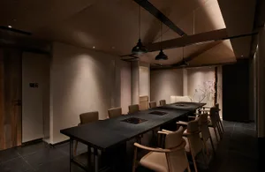 Industrial-style restaurant seating featuring stone tables and wooden chairs.