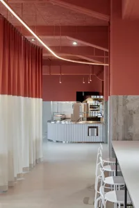 A minimalist cafe interior featuring a concrete and white color scheme.