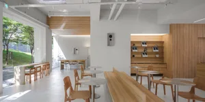 Interior of a modern minimalist restaurant featuring wood and glass materials.